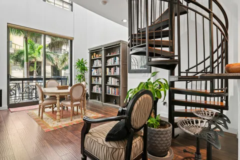 a dining room with furniture potted plants and wooden floor