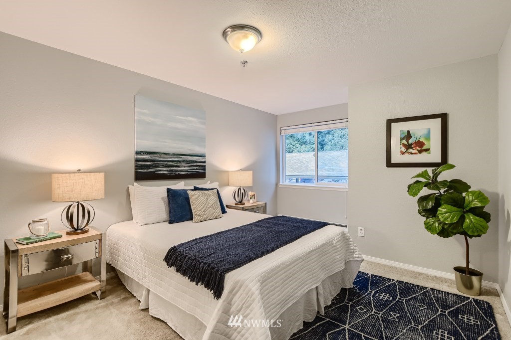 19410 Bothell Way Northeast, Unit D202 Bothell, WA 98011 - Photo 13 of 26 a bedroom with a bed and a chandelier