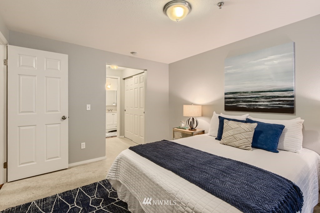 19410 Bothell Way Northeast, Unit D202 Bothell, WA 98011 - Photo 14 of 26 a bedroom with a bed and a chandelier