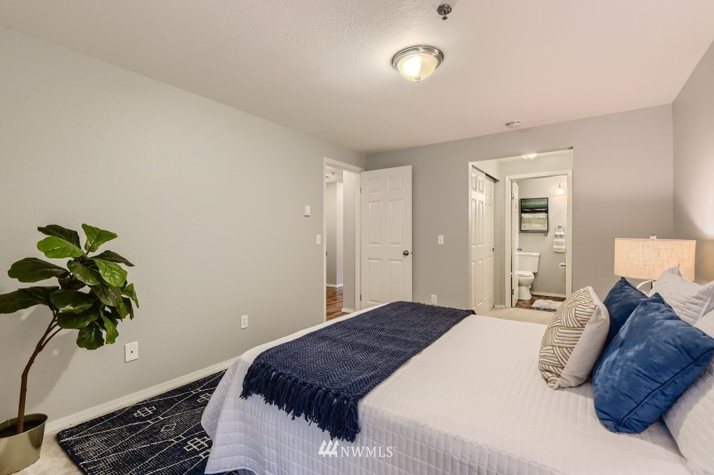 19410 Bothell Way Northeast, Unit D202 Bothell, WA 98011 - Photo 15 of 26 a bedroom with a bed potted plant and a window