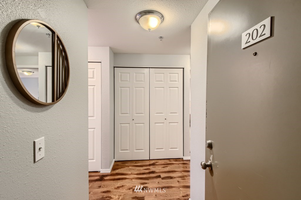 19410 Bothell Way Northeast, Unit D202 Bothell, WA 98011 - Photo 3 of 26 a view of a livingroom with wooden floor and a mirror