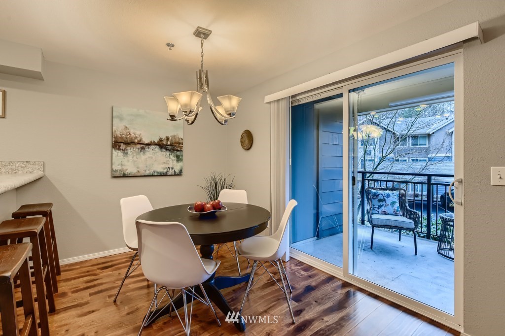19410 Bothell Way Northeast, Unit D202 Bothell, WA 98011 - Photo 10 of 26 a view of a dining room with furniture wooden floor and a chandelier