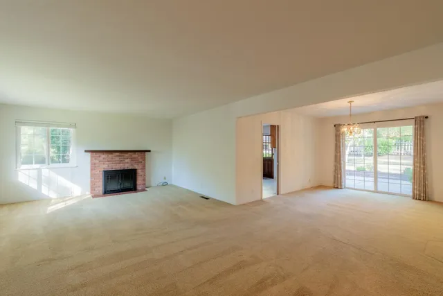 an empty room with windows and a fireplace