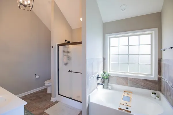 a bathroom with a tub shower and window
