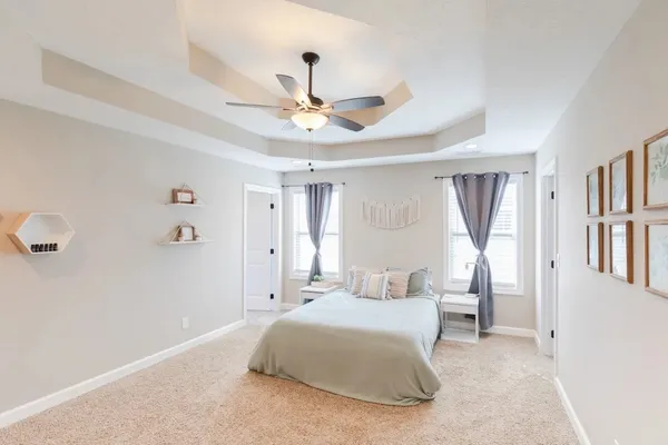 a bedroom with a large bed and a chandelier
