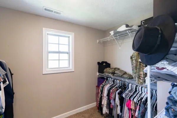 a view of walk in closet with clothes and shoes