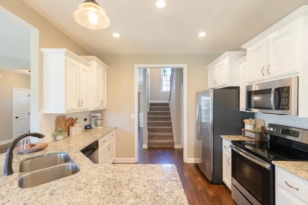 a kitchen with stainless steel appliances granite countertop a sink stove and refrigerator