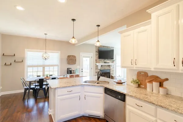 a open kitchen with granite countertop a sink a stove and cabinets