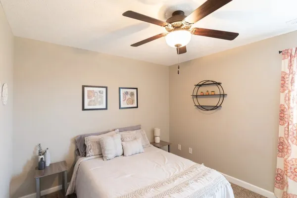 a bedroom with a large bed and a chandelier