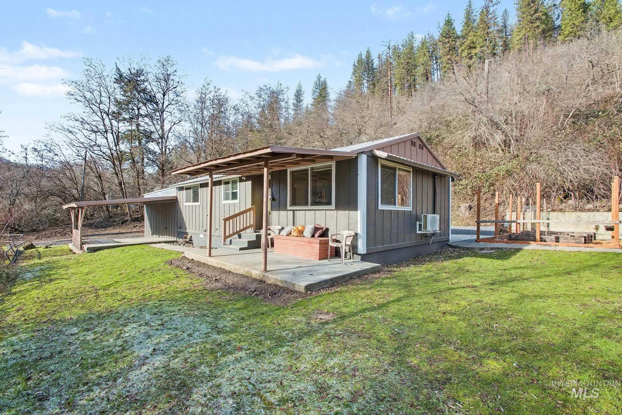 View of front of house with board and batten siding, a front yard, and an attached carport
