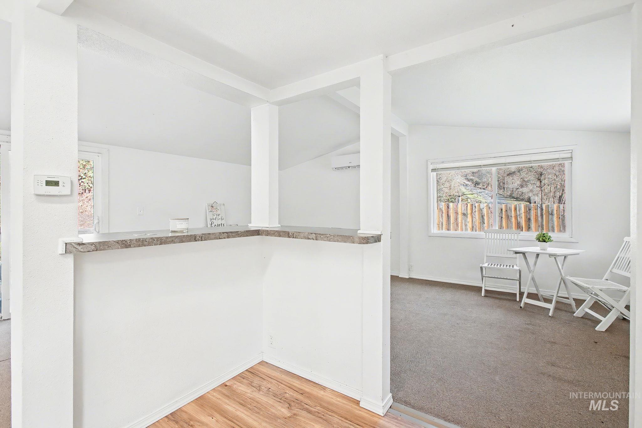 150 Elm Street Orofino, ID 83544 - Photo 7 of 36 Bar area featuring vaulted ceiling, light wood-style flooring, healthy amount of natural light, and a wall mounted AC