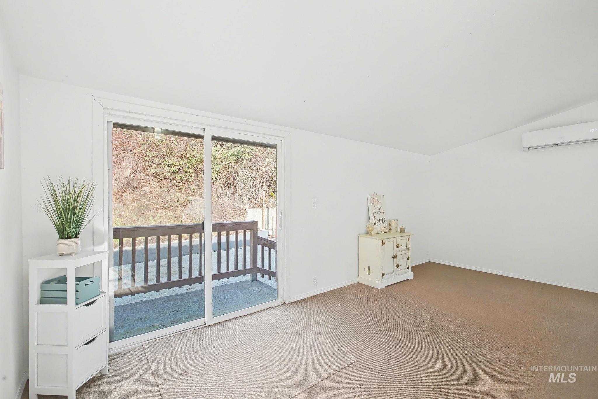 150 Elm Street Orofino, ID 83544 - Photo 10 of 36 Bonus room featuring vaulted ceiling, carpet floors, and an AC wall unit