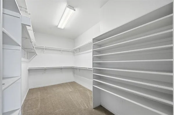 a view of walk in closet with empty racks