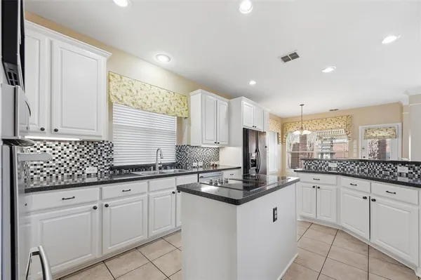 a kitchen with granite countertop white cabinets white appliances with a sink and dishwasher