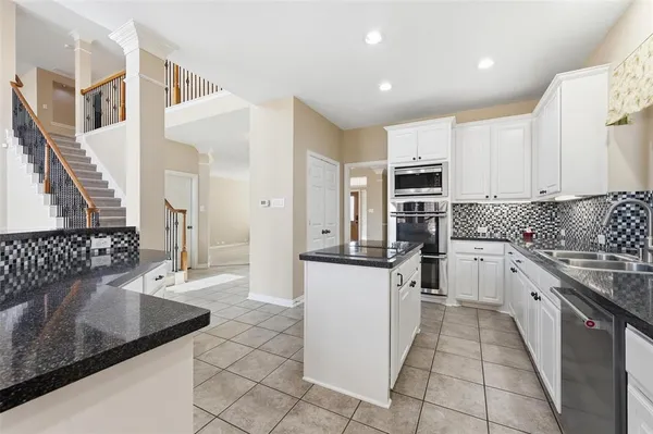 a kitchen with stainless steel appliances granite countertop a sink and a stove