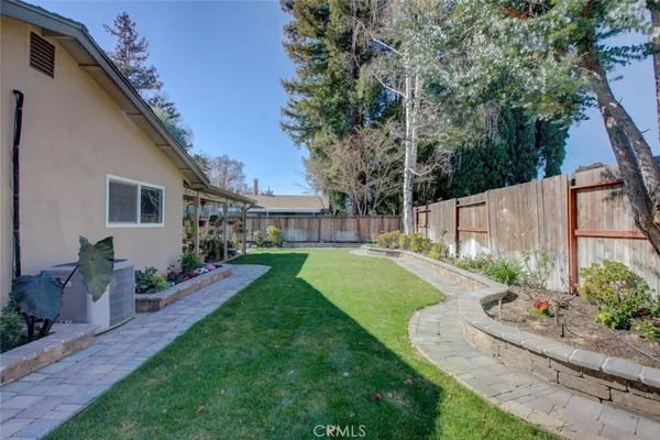 a view of a house with backyard and a garden
