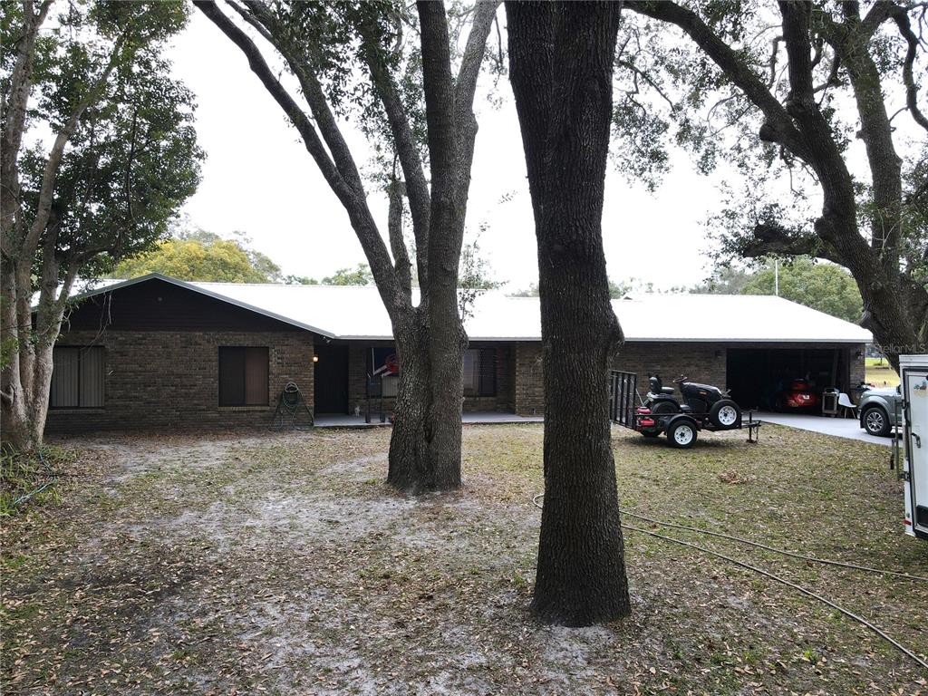 a view of a house with a patio and a large tree