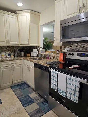a kitchen with stainless steel appliances a sink stove and cabinets