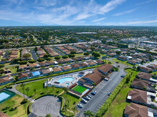 a view of a swimming pool with a bench and lawn chairs