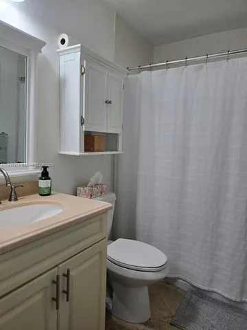 a bathroom with a granite countertop sink mirror vanity and toilet