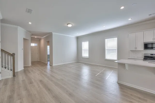 a view of empty room with wooden floor and window