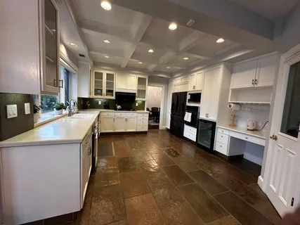 a kitchen with stainless steel appliances kitchen island granite countertop a refrigerator and a stove top oven