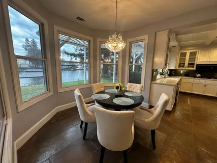 a dining room with furniture a chandelier and window
