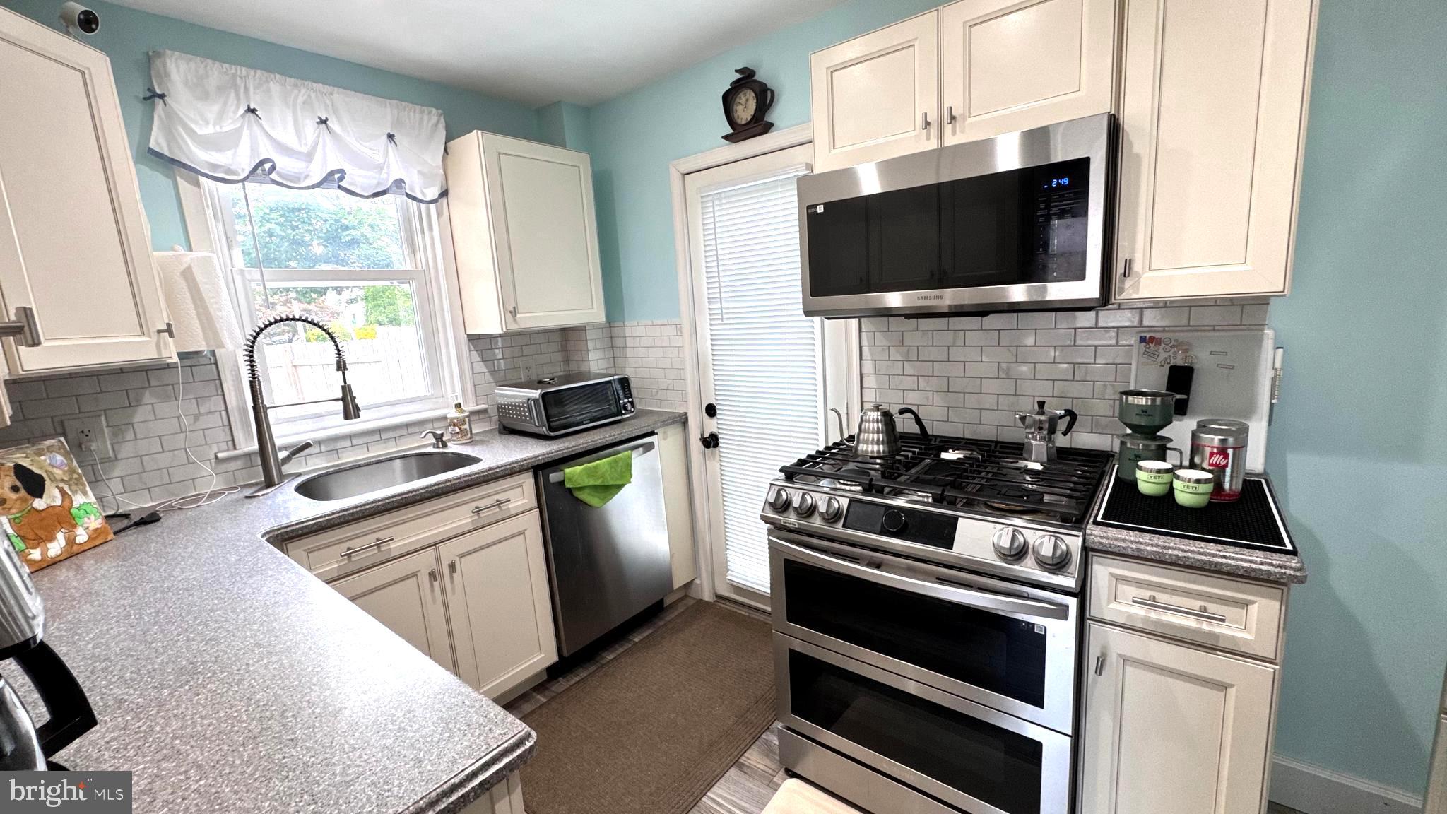 1029 Lamb Road Secane, PA 19018 - Photo 16 of 78 a kitchen with stainless steel appliances a stove microwave and sink