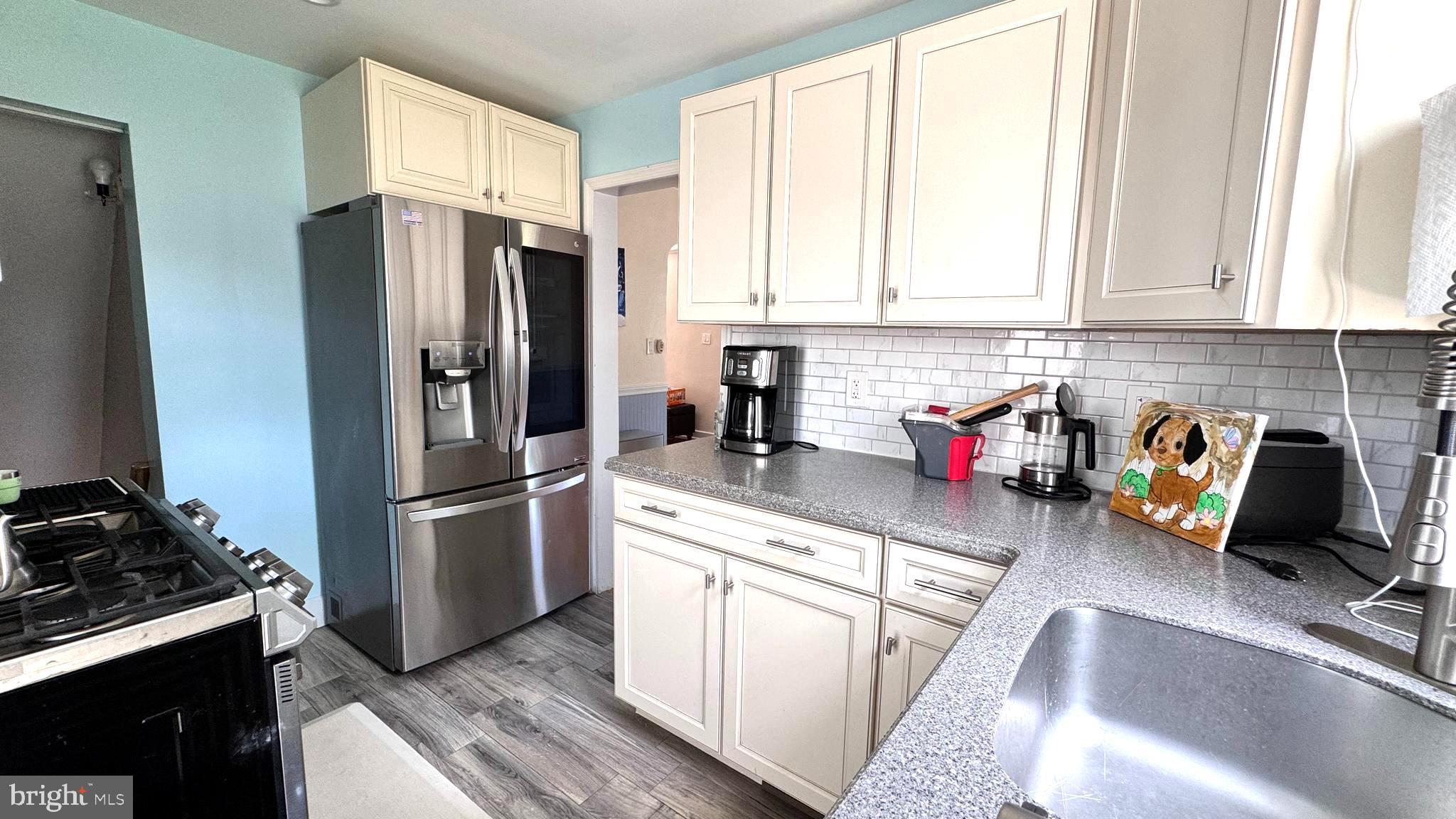 1029 Lamb Road Secane, PA 19018 - Photo 19 of 78 a kitchen with a refrigerator stove and white cabinets
