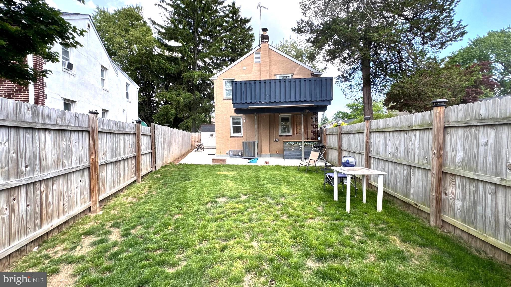 1029 Lamb Road Secane, PA 19018 - Photo 59 of 78 a view of backyard with table and chairs and wooden fence