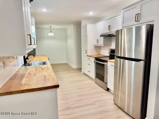 a kitchen with granite countertop a refrigerator and a sink