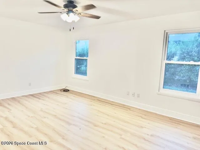 an empty room with a window and a fan