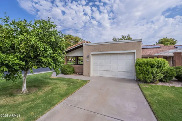 a front view of a house with a garden and yard