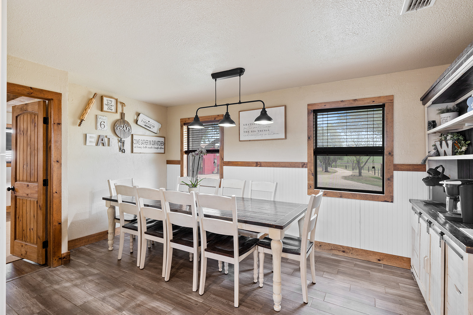 1001 Gravel Pit Road Taylor, TX 76574 - Photo 10 of 38 Dining space featuring light wood finished floors, healthy amount of natural light, a wainscoted wall, and a textured ceiling