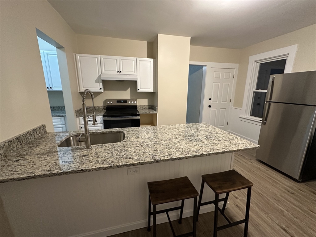 71 Flagg Street, Unit 2 Clinton, MA 01510 - Photo 11 of 13 a kitchen with stainless steel appliances granite countertop a stove refrigerator sink and microwave