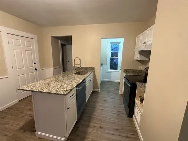 a kitchen with granite countertop kitchen island wooden cabinets and stainless steel appliances
