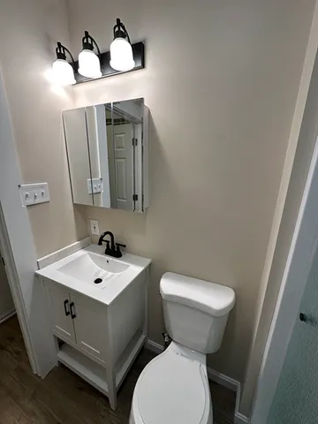 a bathroom with a toilet sink and mirror
