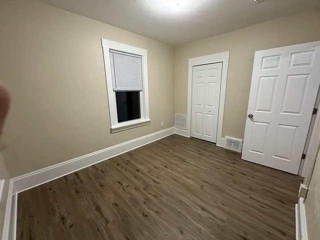 an empty room with wooden floor and closet