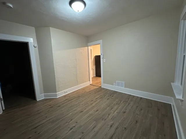 an empty room with wooden floor and closet