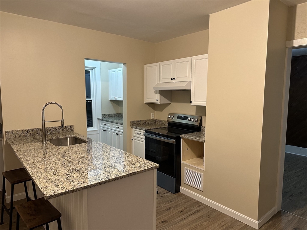 71 Flagg Street, Unit 2 Clinton, MA 01510 - Photo 10 of 13 a kitchen with granite countertop a sink cabinets and stainless steel appliances