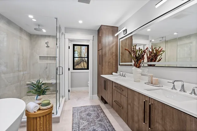 a spacious bathroom with a double vanity sink a large mirror and a shower