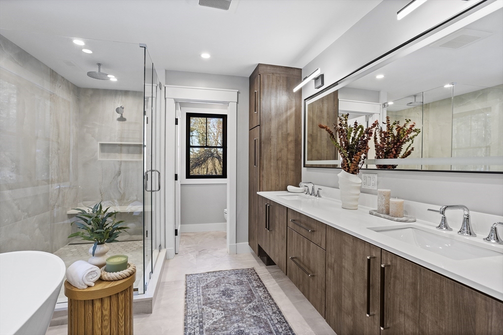 236 Fairhaven Road Concord, MA 01742 - Photo 19 of 35 a spacious bathroom with a double vanity sink a large mirror and a shower