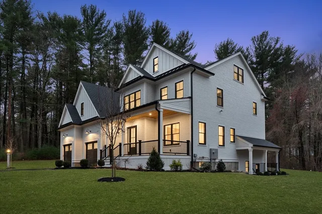 a front view of a house with a garden and trees