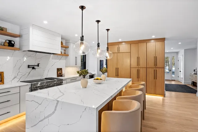 a kitchen with stainless steel appliances granite countertop a sink a refrigerator and a stove