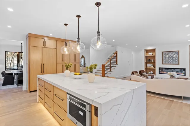 a large kitchen with kitchen island a stove a sink a center island a dining table and chairs