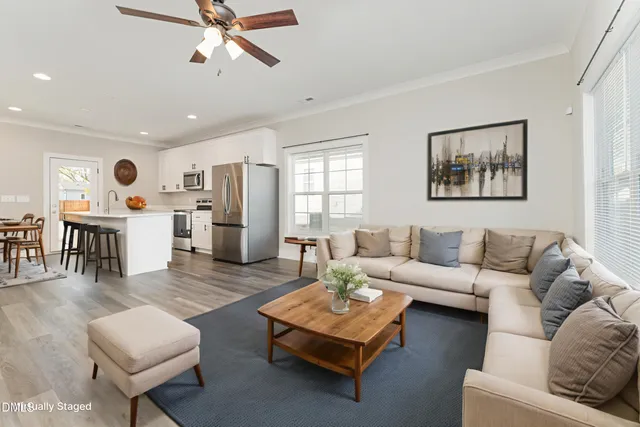 a living room with furniture and kitchen view