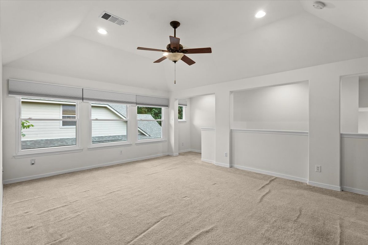 2304 Village View Loop Pflugerville, TX 78660 - Photo 32 of 40 A versatile bonus room offers vaulted ceilings and soft carpet, ready for personalization.