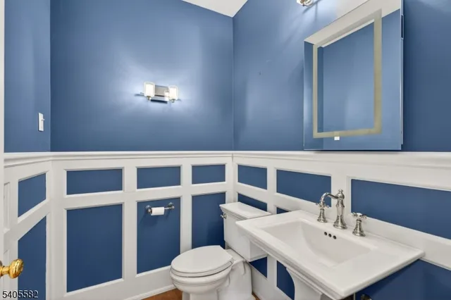 a kitchen with stainless steel appliances a stove a sink a refrigerator white cabinets and wooden floor