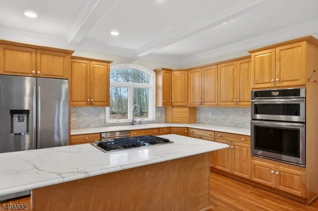 a kitchen with stainless steel appliances granite countertop a stove a refrigerator and a sink