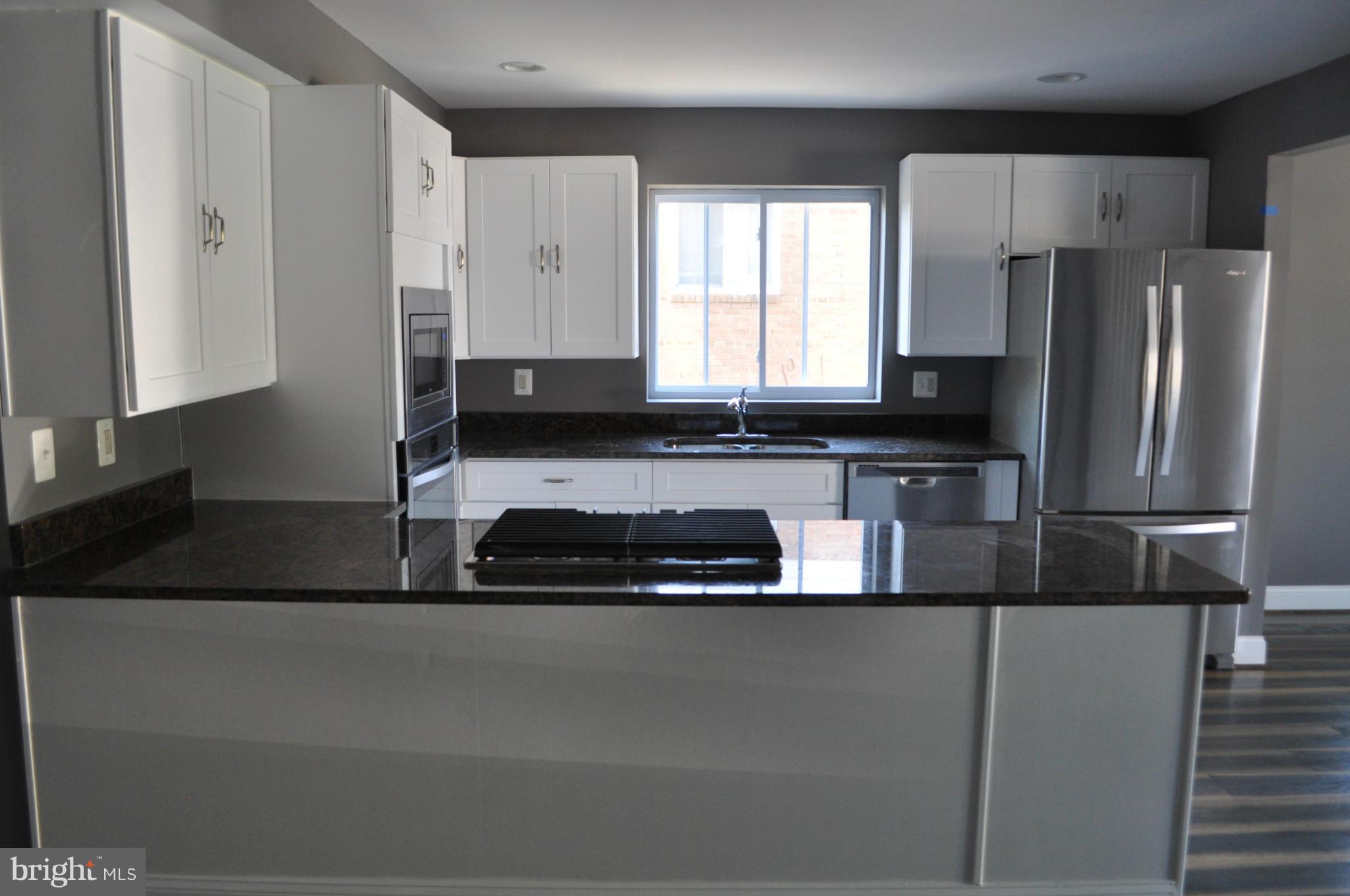 4909 Fitch Place Northeast Washington, DC 20019 - Photo 13 of 30 a kitchen with stainless steel appliances granite countertop a sink a stove a refrigerator a washer and dryer
